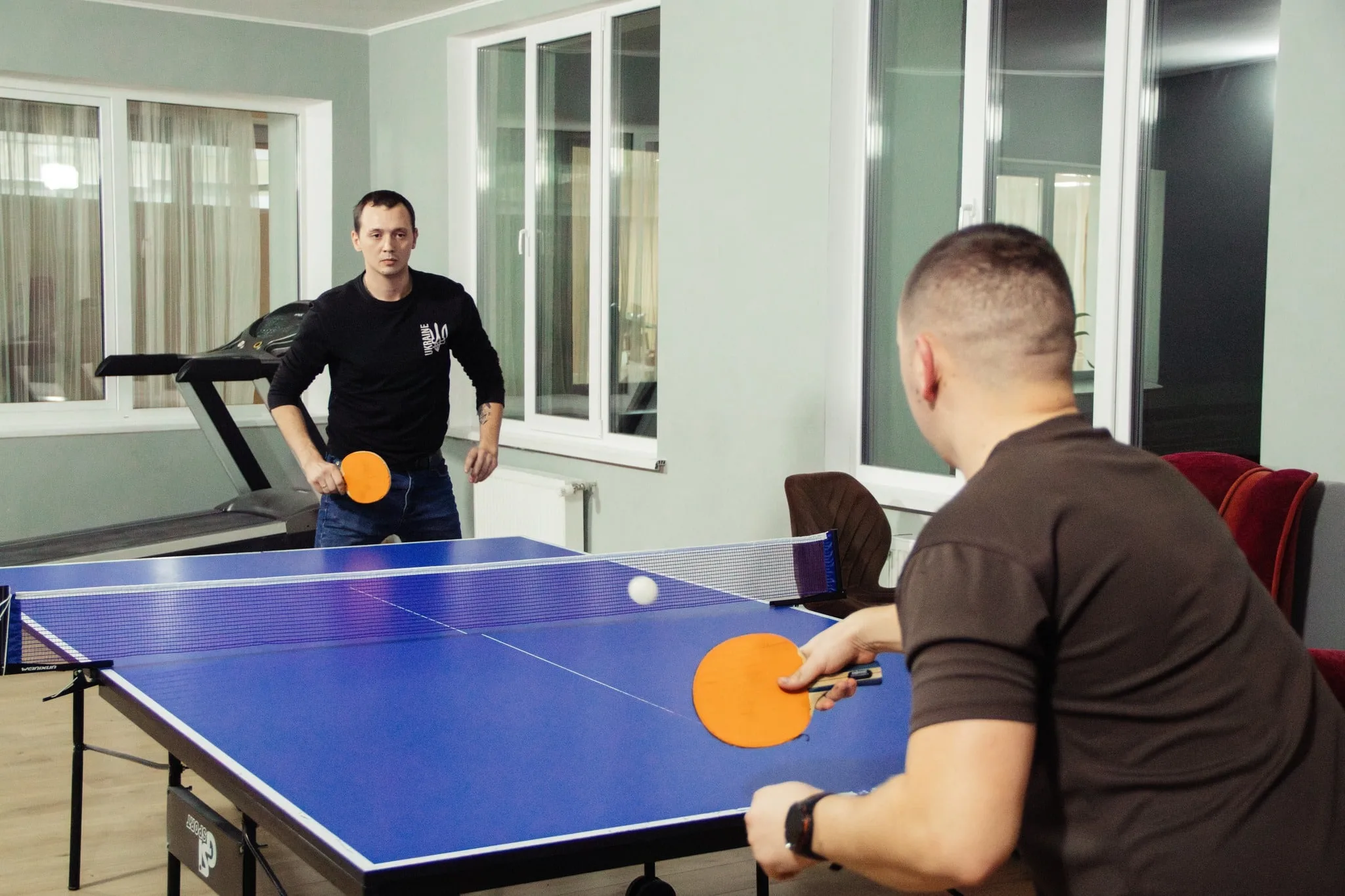 Двоє чоловіків грають у настільний теніс