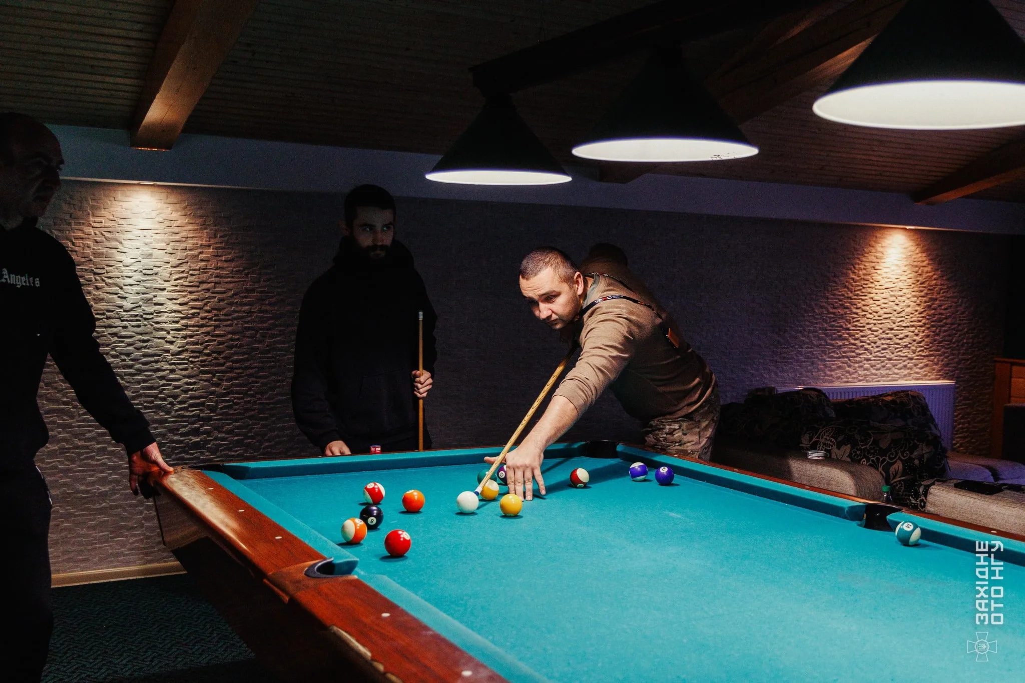 Чоловіки грають у більярд у кімнаті відпочинку