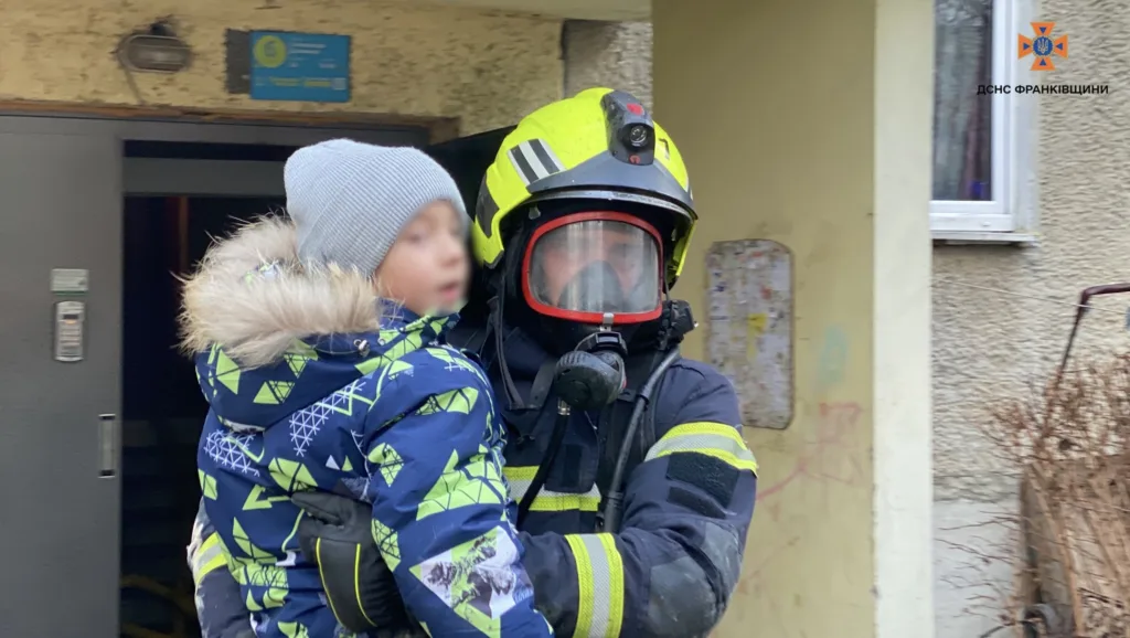Рятувальник несе дитину з будівлі