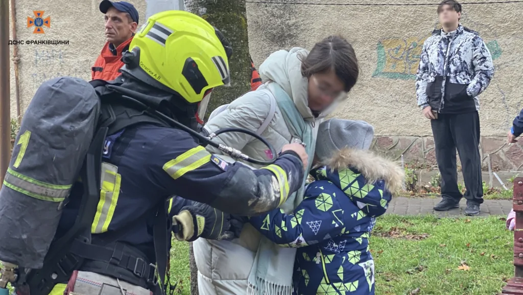 Рятувальник допомагає матері з дитиною на вулиці