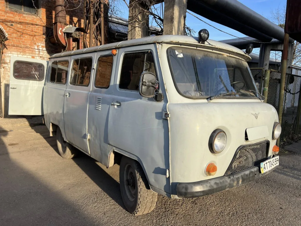 Сірий мікроавтобус біля цегляної будівлі