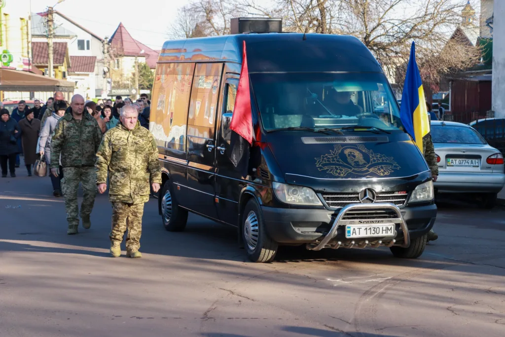 Військові супроводжують катафалк із прапорами України