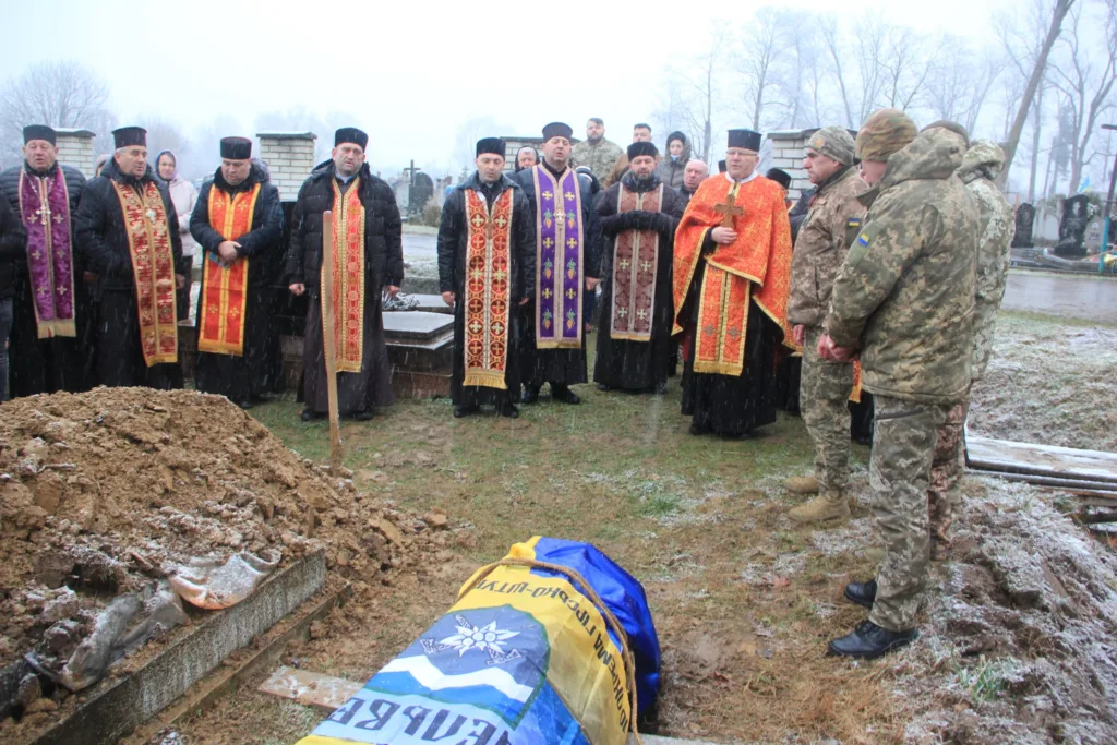 Священники та військові на похороні героя