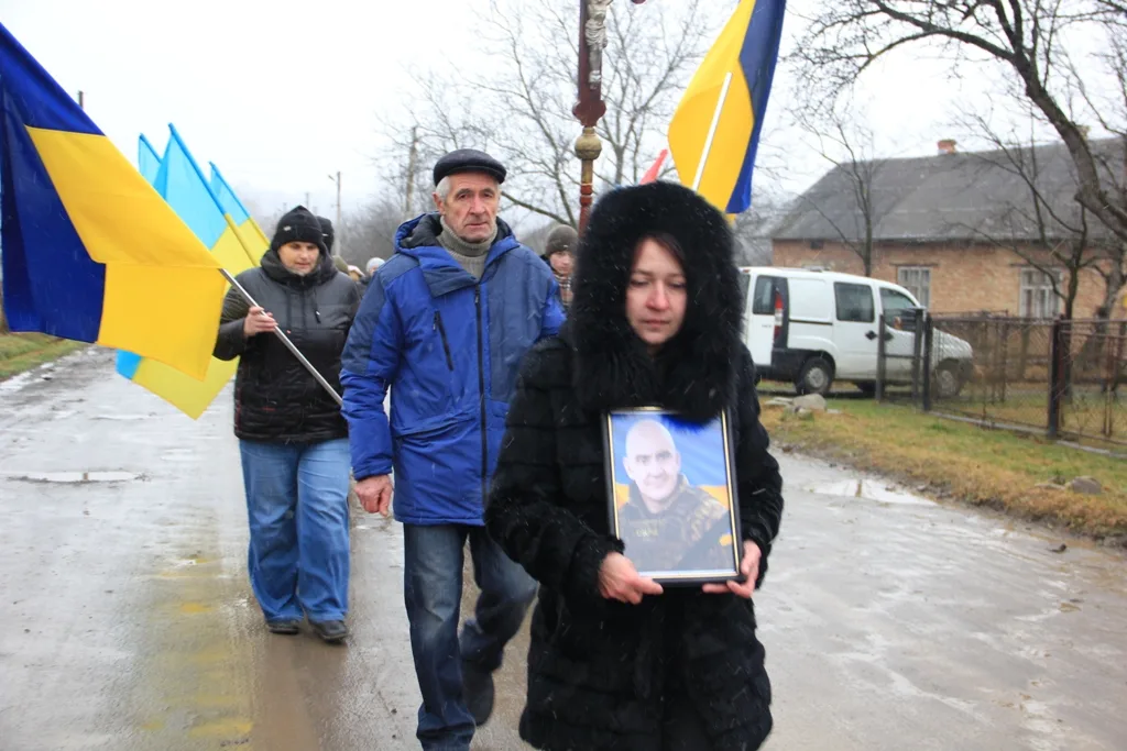 Похоронна процесія з українськими прапорами