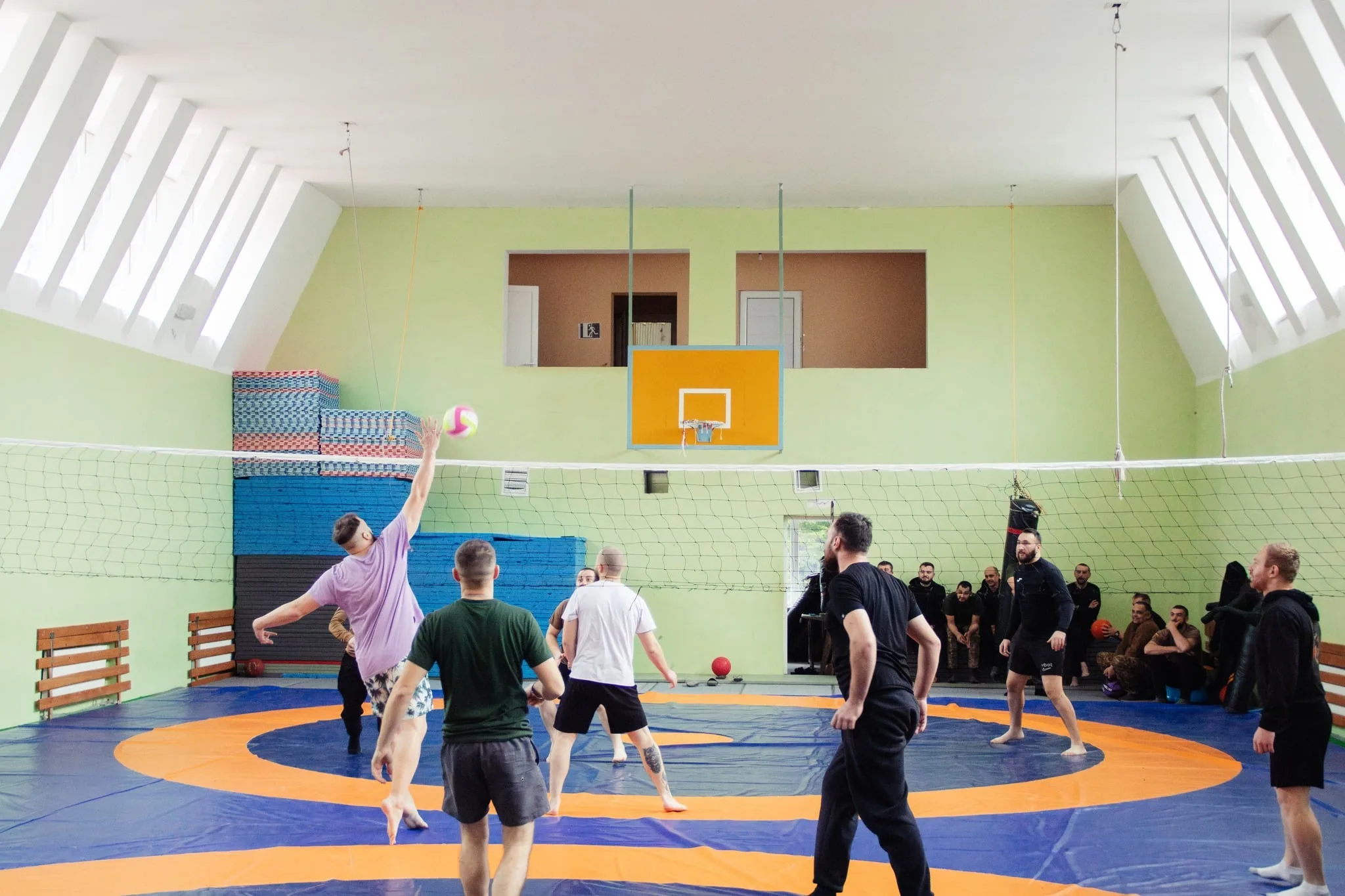 Чоловіки грають у волейбол у спортивному залі