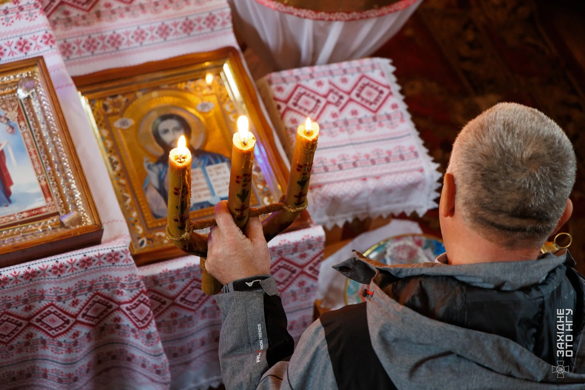 Молитва з трьома свічками перед іконою