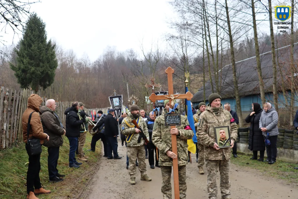 Військові несуть хрест і портрет загиблого героя
