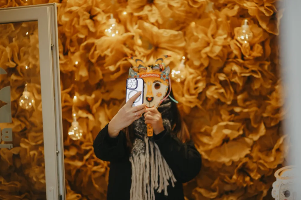 Людина з маскою робить селфі перед дзеркалом