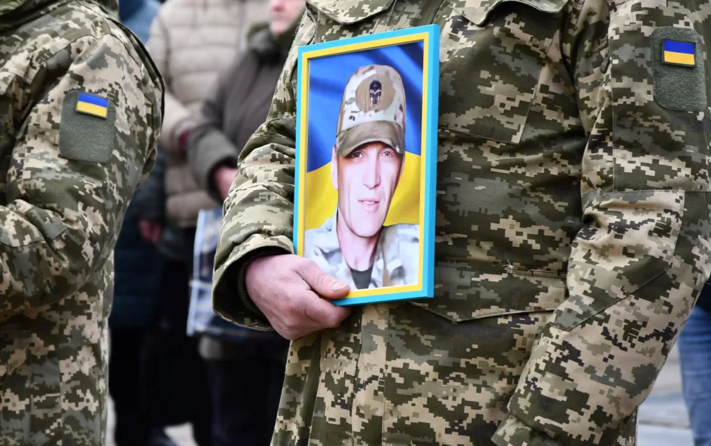 Військовий тримає фото загиблого товариша