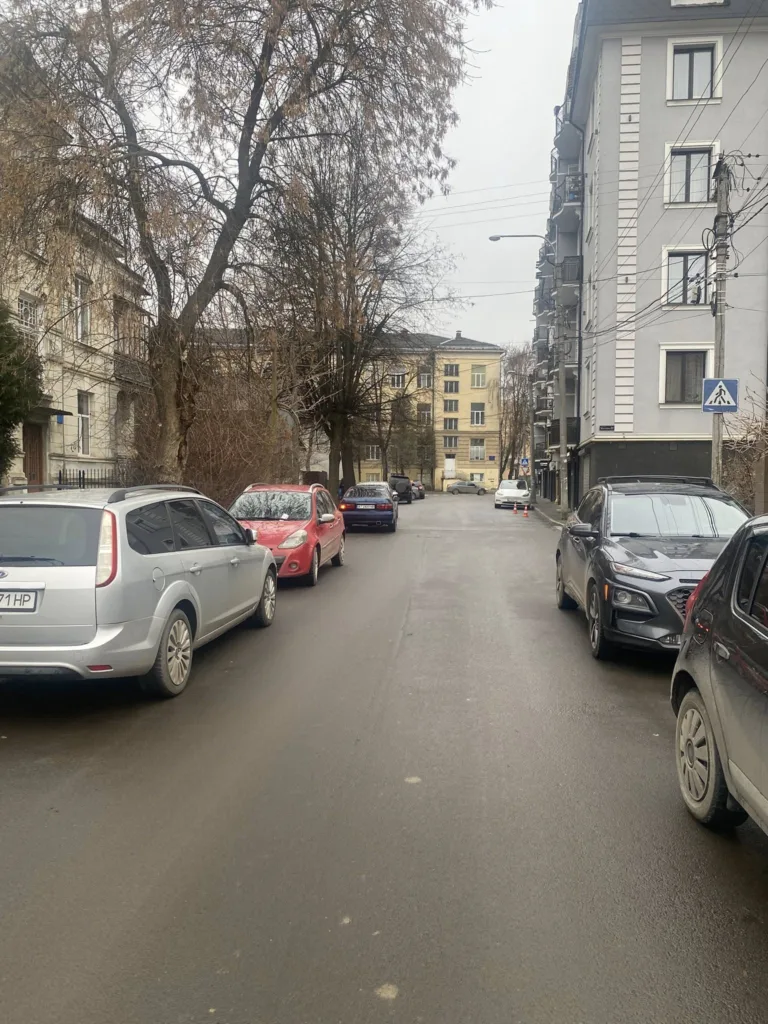 Вулиця з припаркованими автомобілями біля житлових будинків