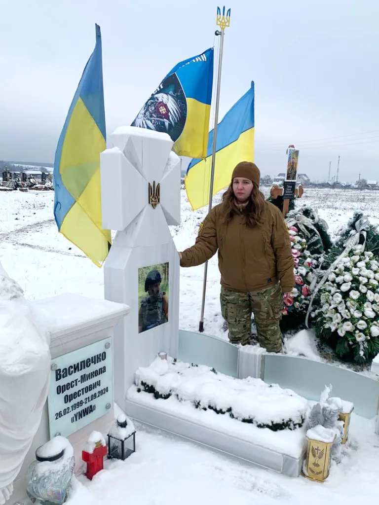 Могила військового з українськими прапорами взимку