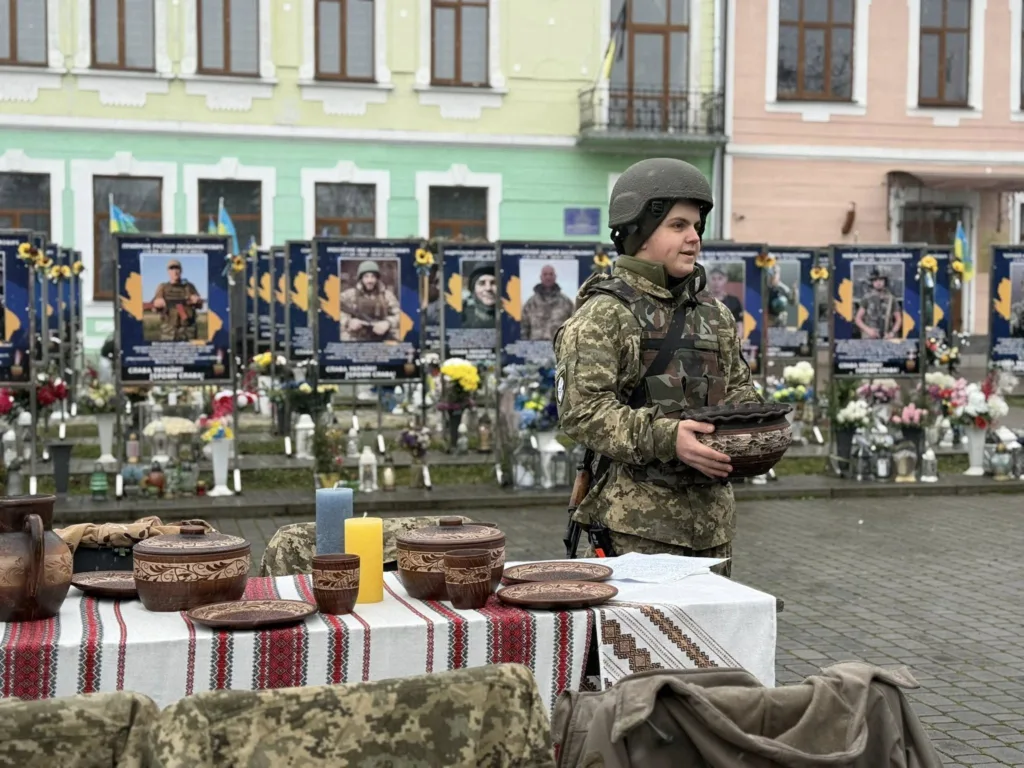 Військовий на вшануванні героїв з традиційними стравами