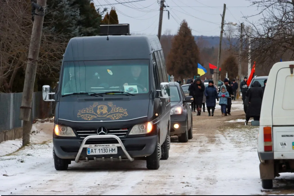 Автоколона з людьми та українськими прапорами взимку