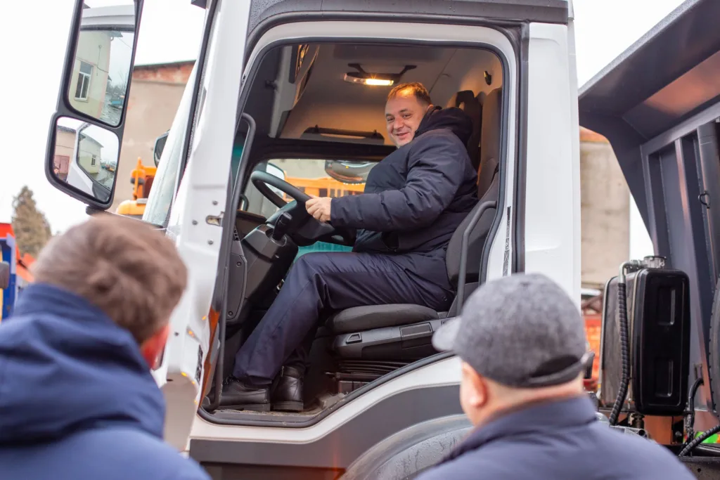 Чоловік сидить у кабіні вантажівки