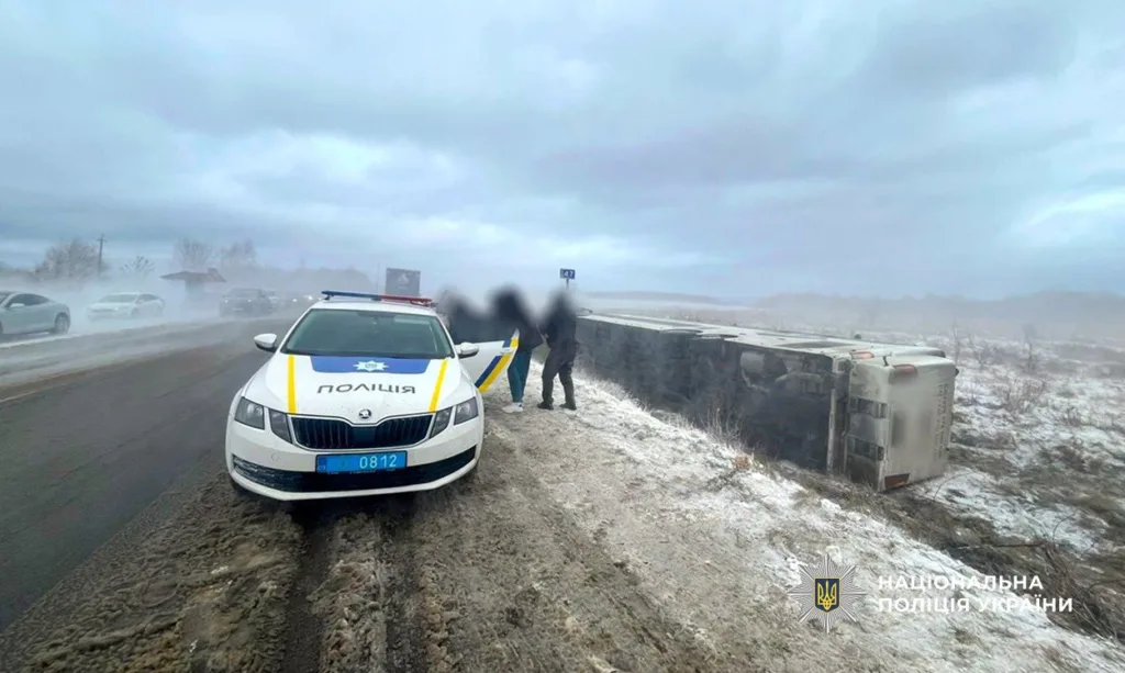 Поліція біля перекинутого автобуса на засніженій трасі