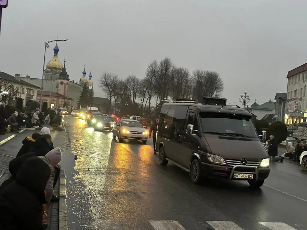 Автомобілі їдуть мокрою вулицею біля церкви