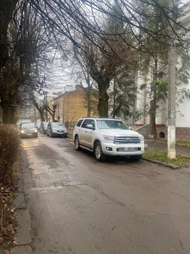 Автомобілі припарковані на вулиці біля будинків