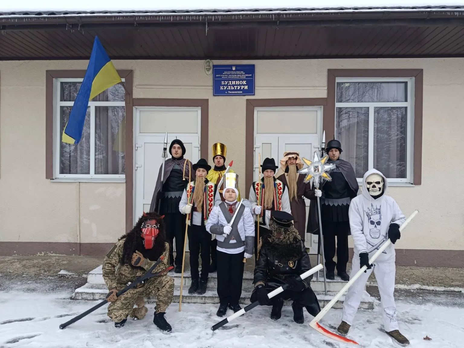 Група людей у костюмах біля будинку культури