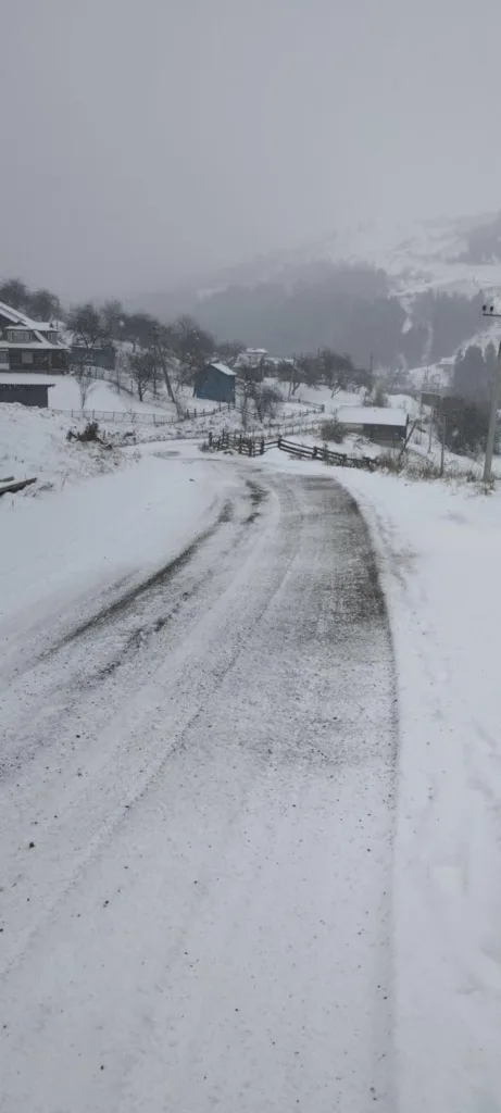 Засніжена сільська дорога в гірській місцевості