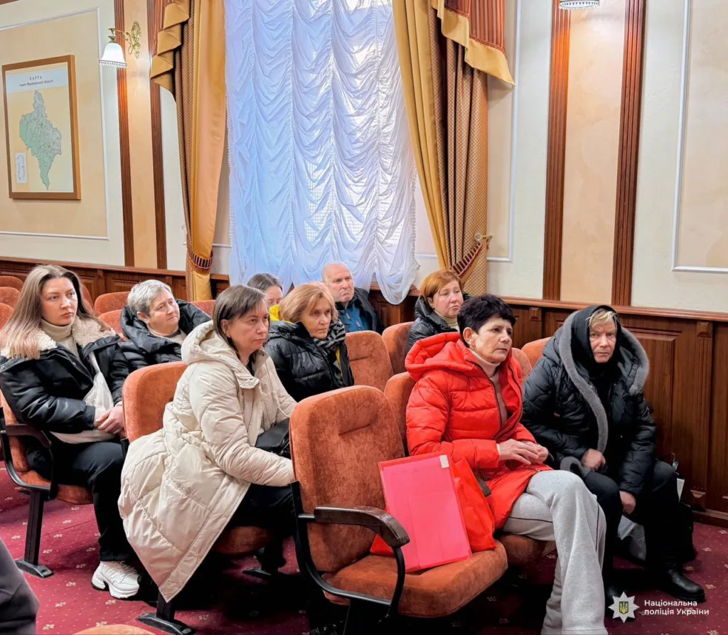 Люди сидять у залі на зустрічі з поліцією