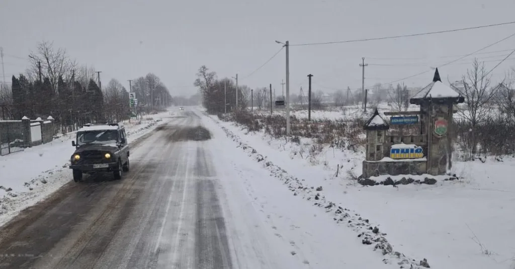 Засніжена дорога та в'їзд у місто під снігом