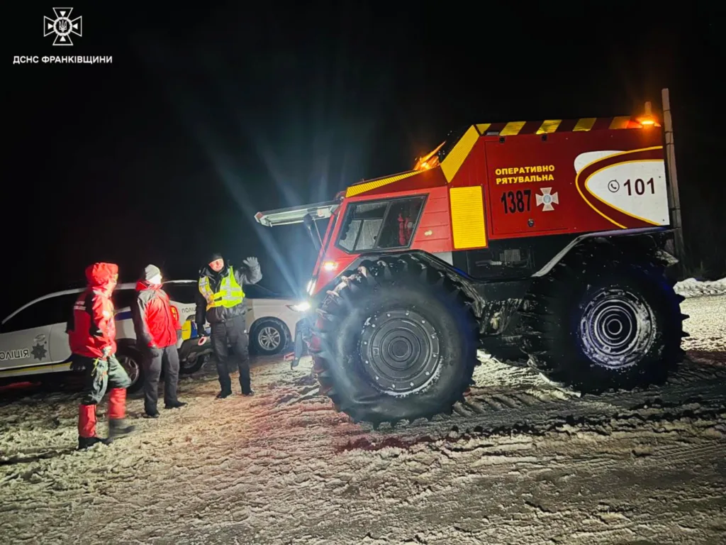 Рятувальники та поліція на засніженій дорозі вночі