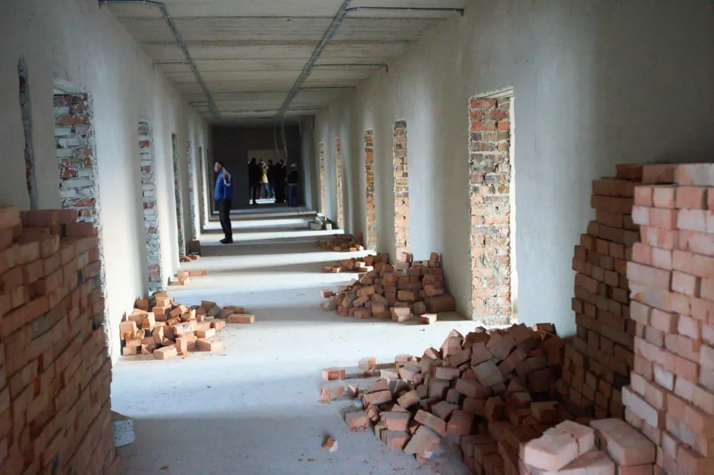 Будівельний коридор з цеглою та людьми всередині