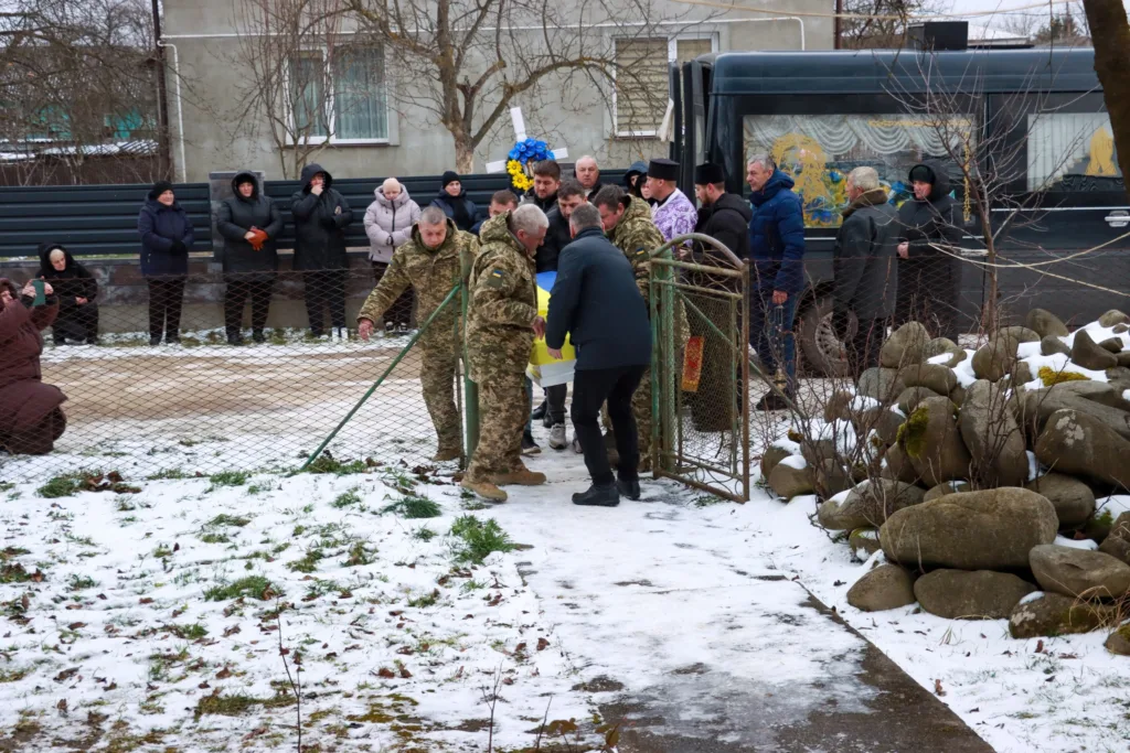 Військові несуть труну під час похорону взимку