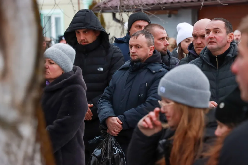 Люди стоять на вулиці в зимовому одязі