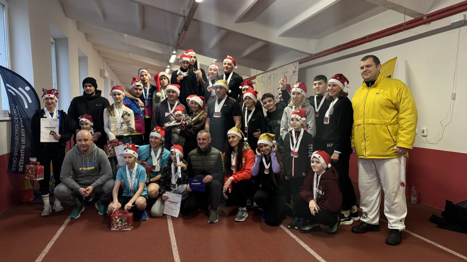 Групове фото спортсменів у новорічних шапках після забігу