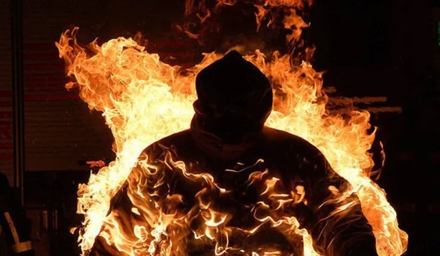 Людина в полум'ї у темряві