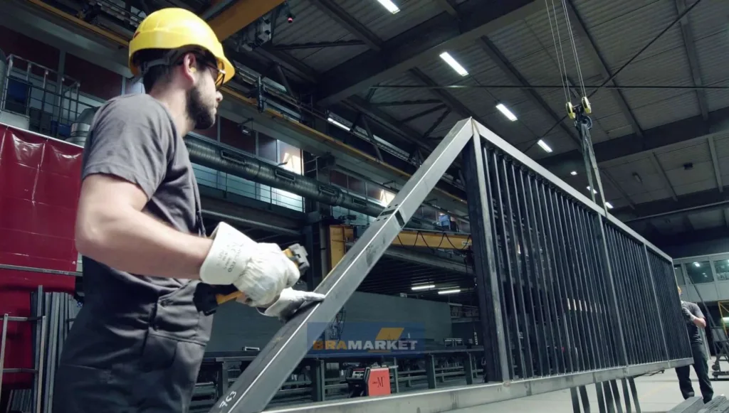 Робітник виготовляє металеві ворота на заводі