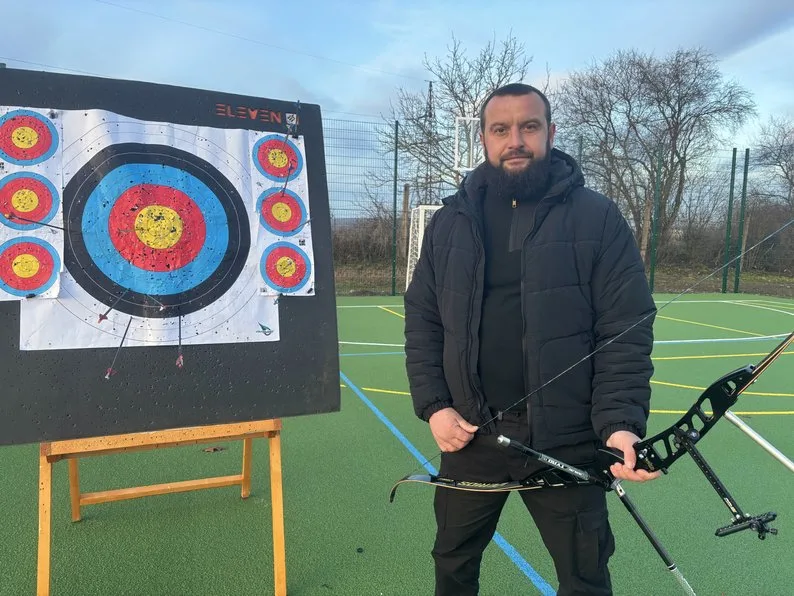 Чоловік із луком біля мішені для стрільби