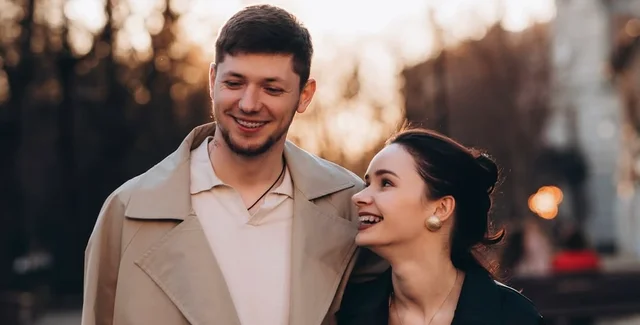 Молода пара усміхається під час прогулянки містом