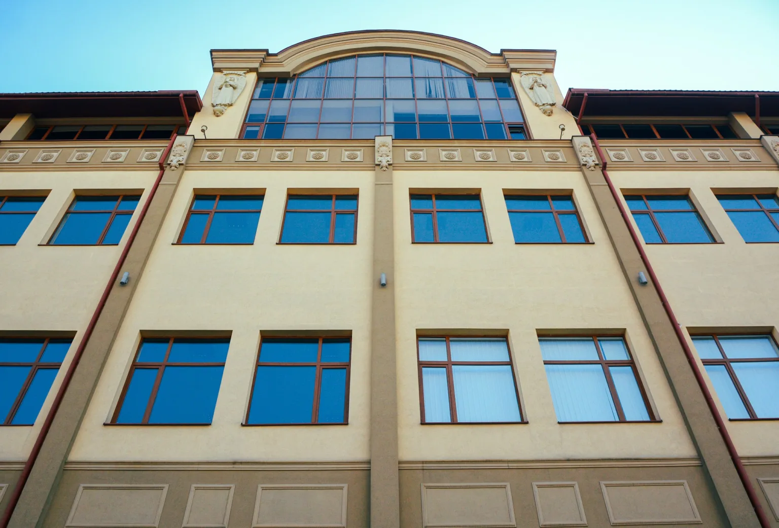 Сучасна будівля з великими вікнами та аркою