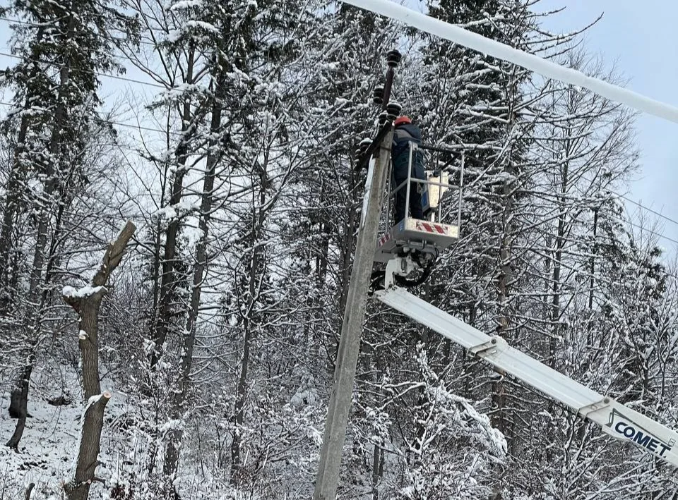 Монтаж електролінії взимку у сніжному лісі