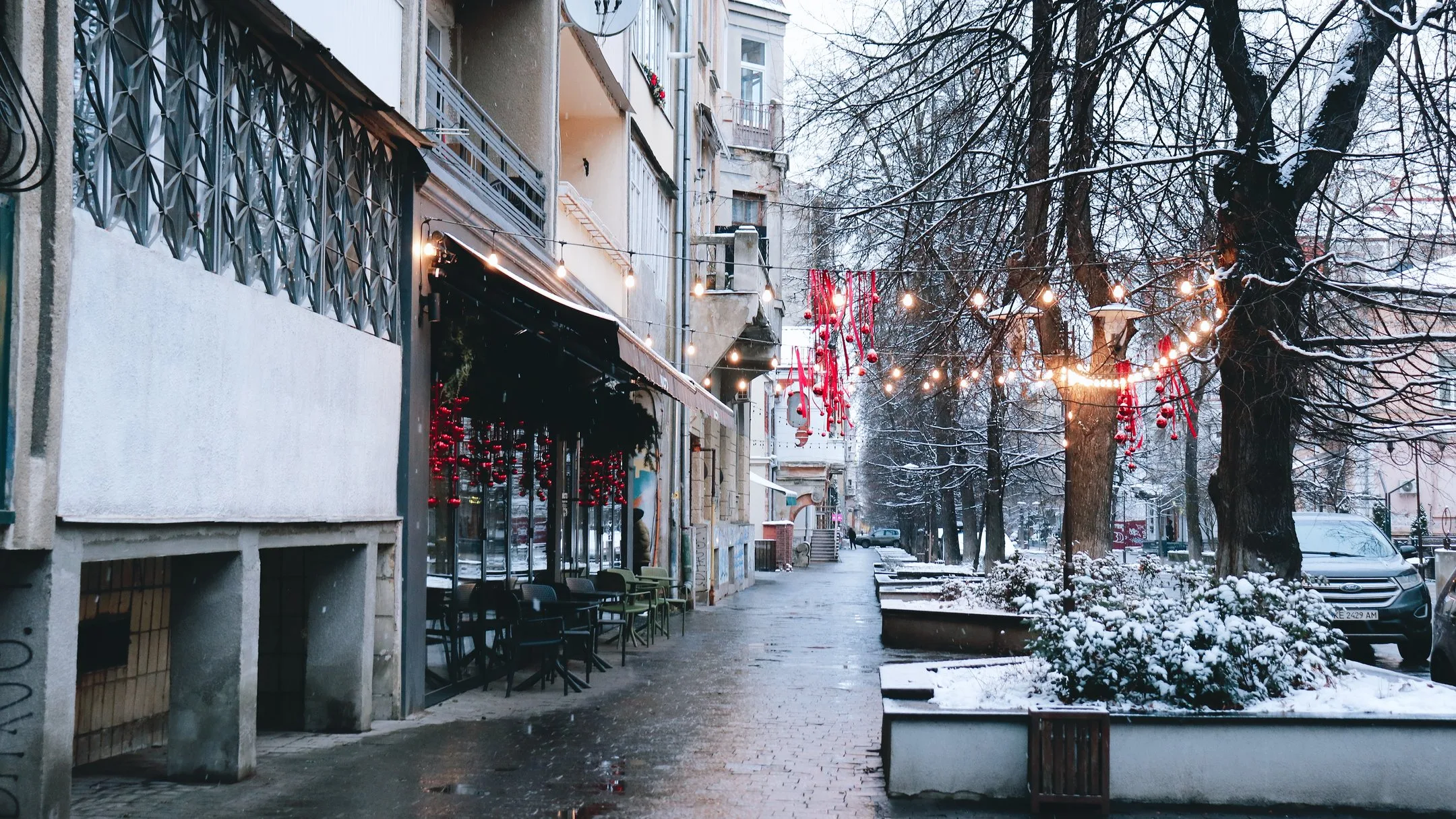 Зимова міська вулиця з гірляндами та кафе