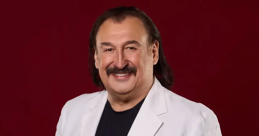 Чоловік у білому піджаку на червоному тлі