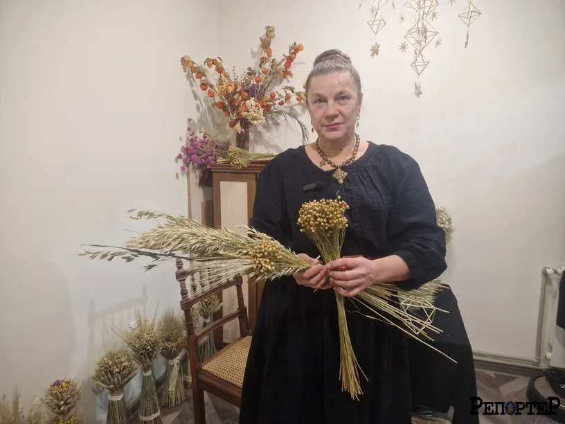 Жінка тримає пучки зерна у кімнаті