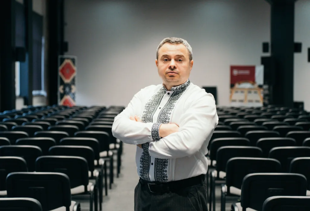 Чоловік у вишиванці стоїть у залі конференцій