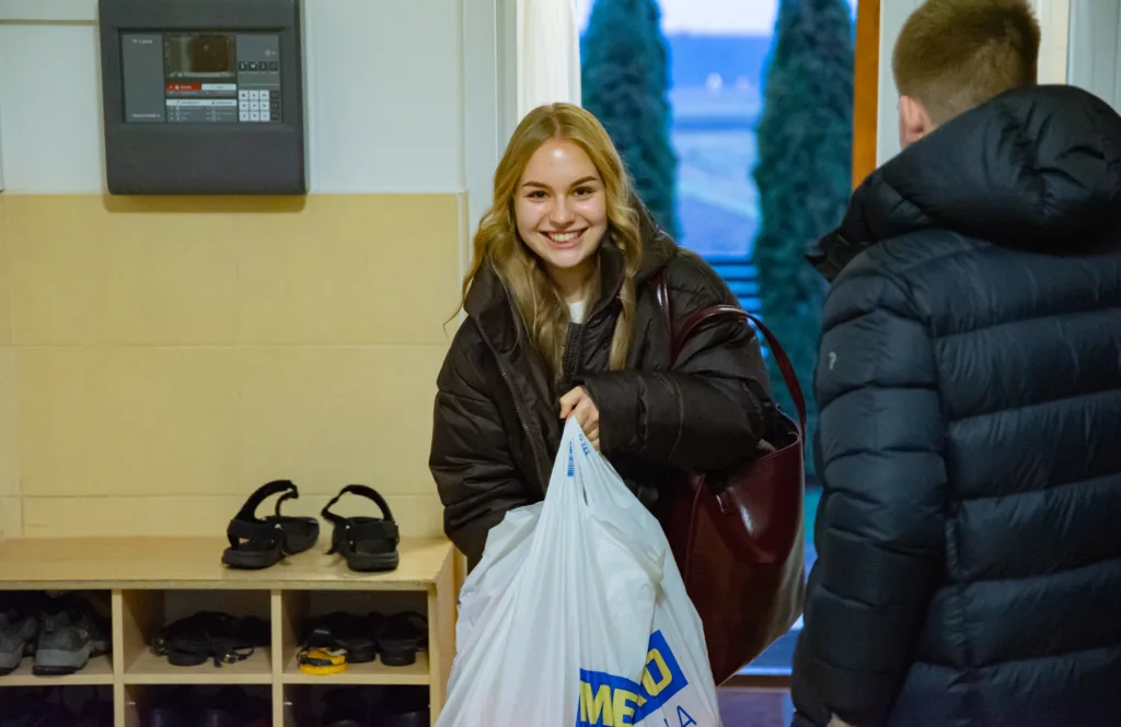 Дівчина з пакетом заходить до будинку