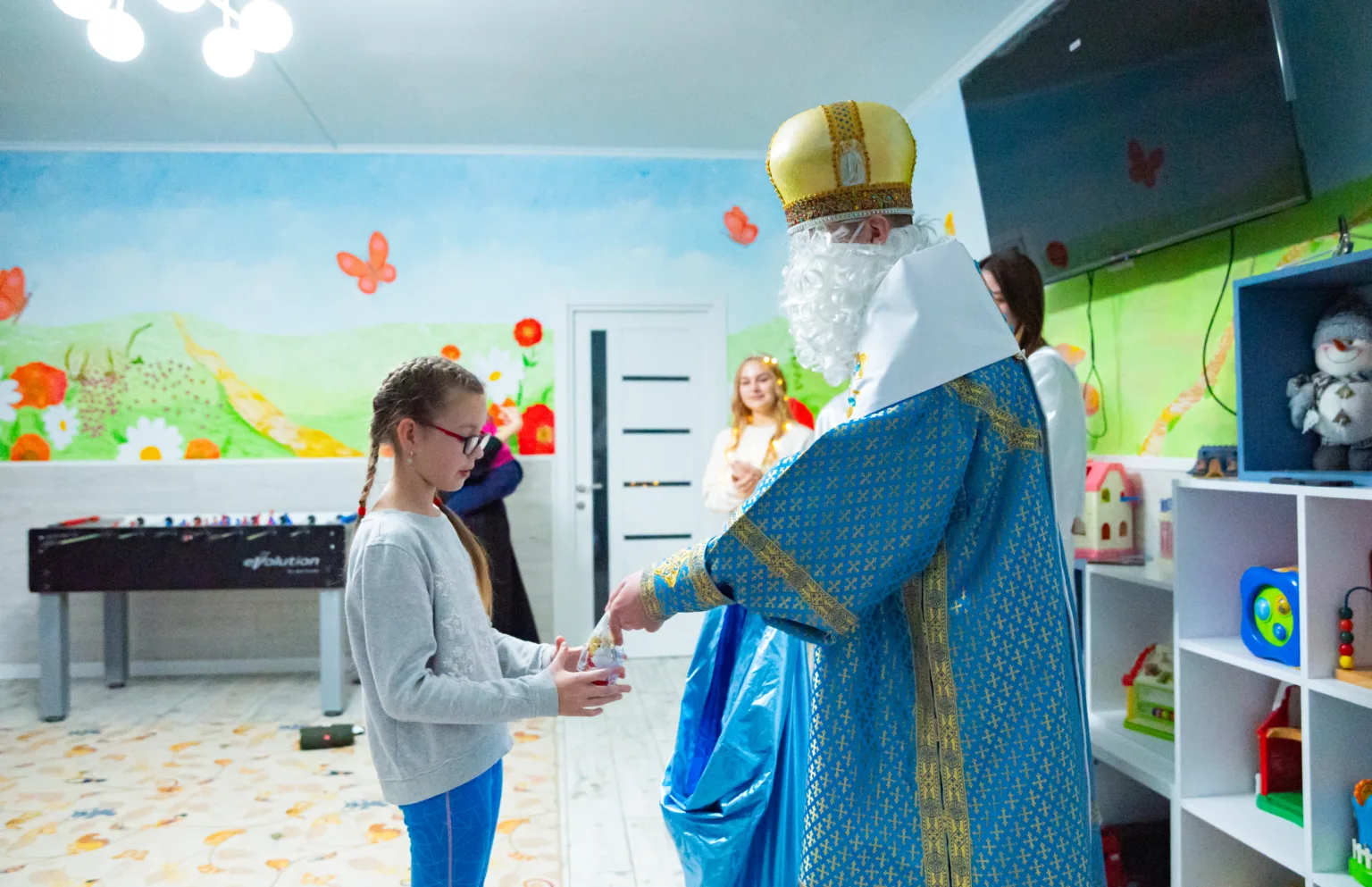 Святий Миколай дарує подарунок дитині