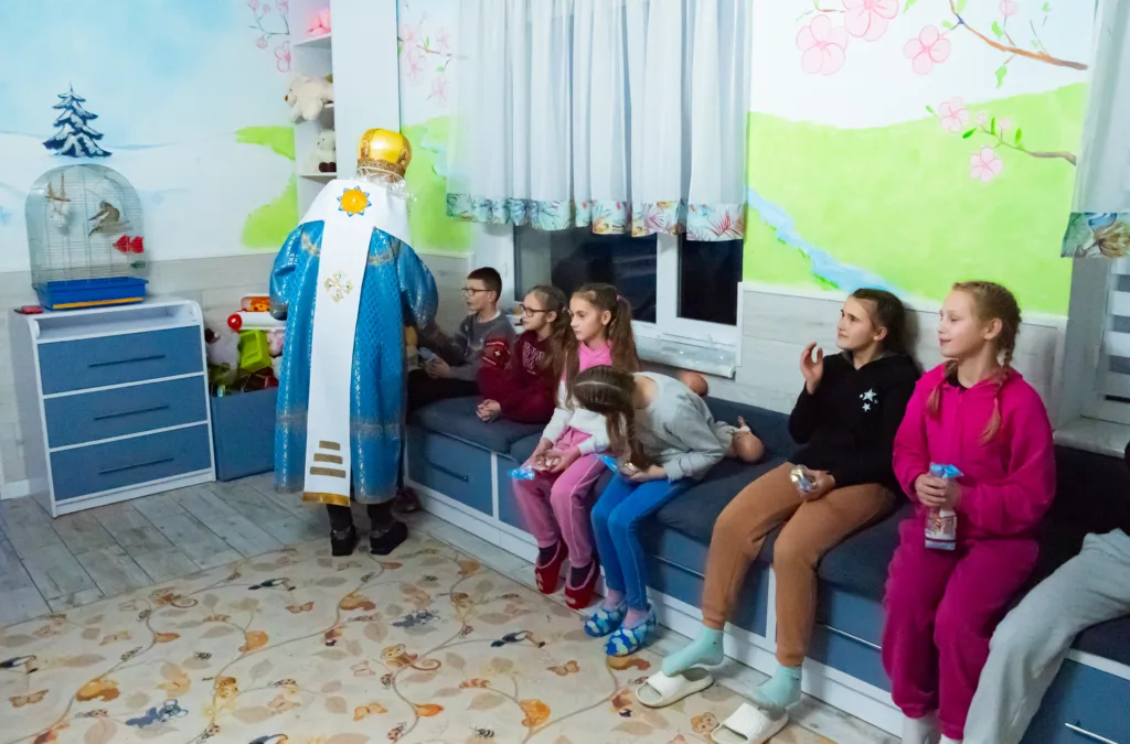 Святий Миколай дарує подарунки дітям у кімнаті