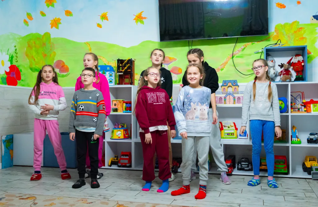 Діти співають у дитячій кімнаті з іграшками