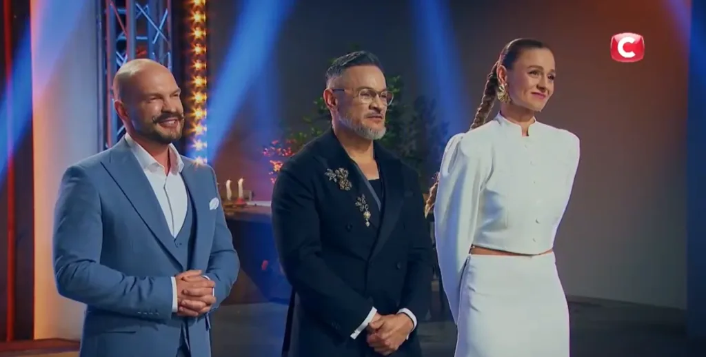 Троє суддів кулінарного шоу стоять на сцені