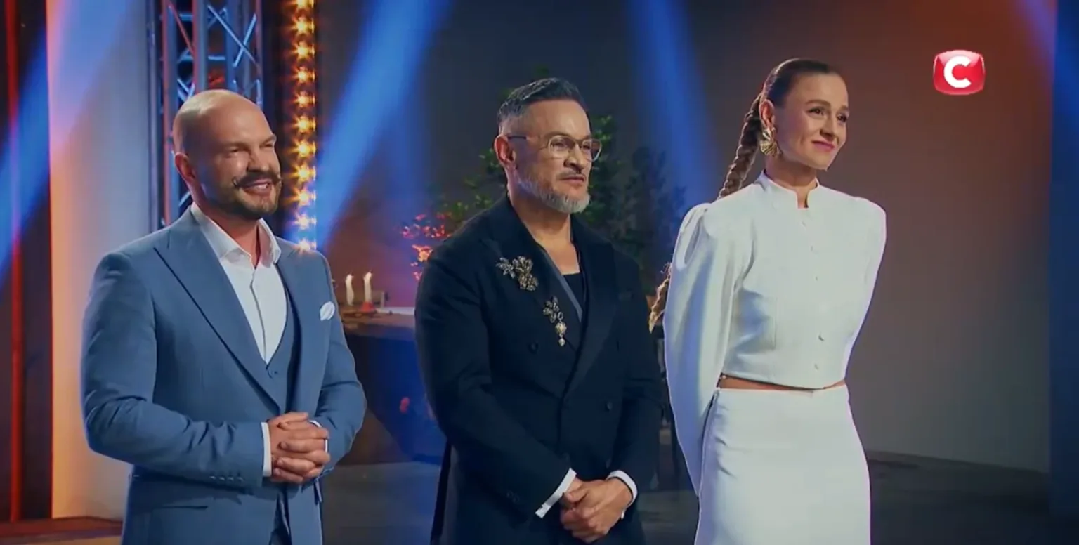 Троє суддів кулінарного шоу стоять на сцені