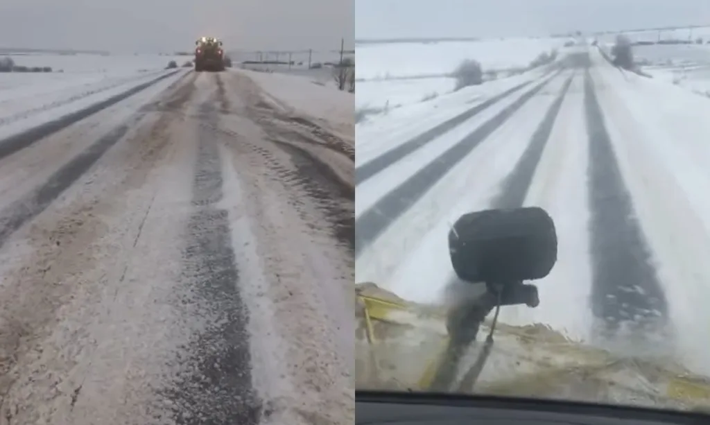 Засніжена дорога з трактором у зимовому полі