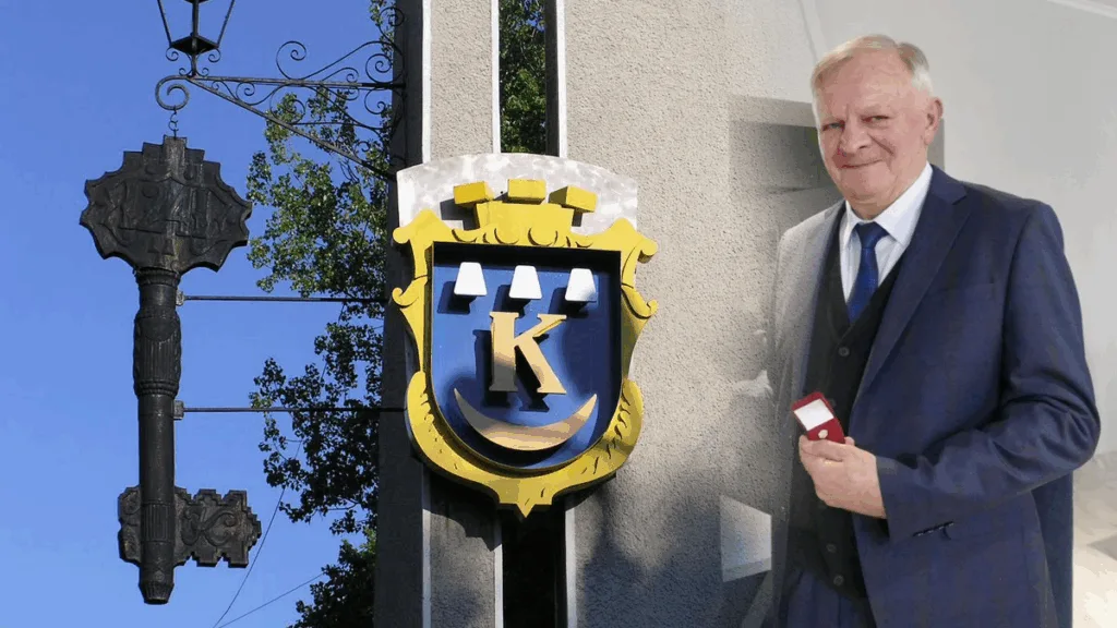 Чоловік тримає медаль біля герба міста.