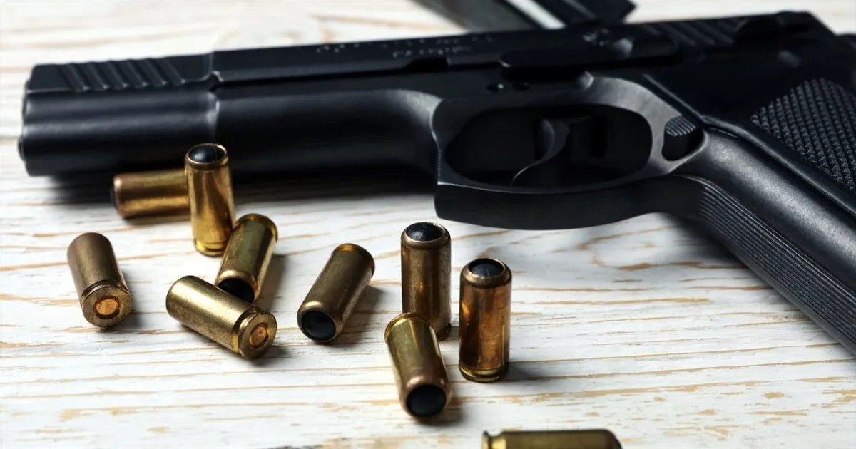 Пістолет і кулі на дерев'яному столі