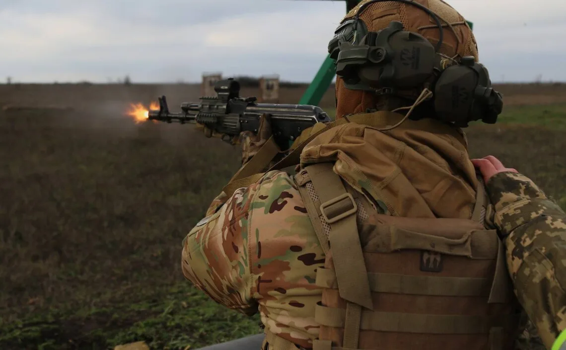 Військовий стріляє з кулемета на полігоні